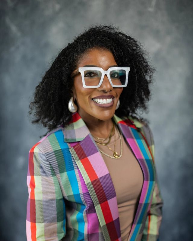Studio headshot, plaid blazer, gray backdrop